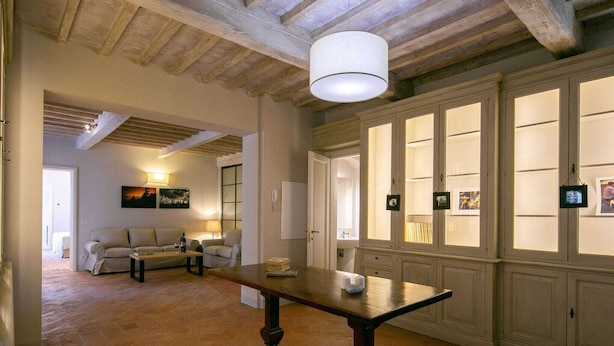 A spacious room with a wooden table, a sofa, and a large window with multiple panes.