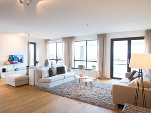 Una sala de estar moderna con un sofá, una mesa de centro y un televisor.