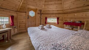 A wooden cabin room with a bed, a table, and a dining area. - Leven View Lodges near Glencoe No2 Callart (Fort William)