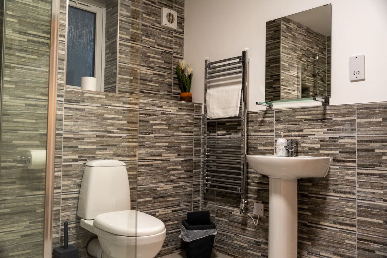 Un bagno moderno con servizi igienici, lavabo e cabina doccia in vetro.