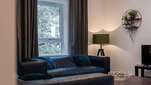 A modern living room with a leather sofa, a side table, a lamp, and a wall-mounted plant shelf.