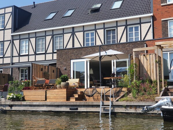 A residential property with a dock, outdoor seating, and a motorized boat.