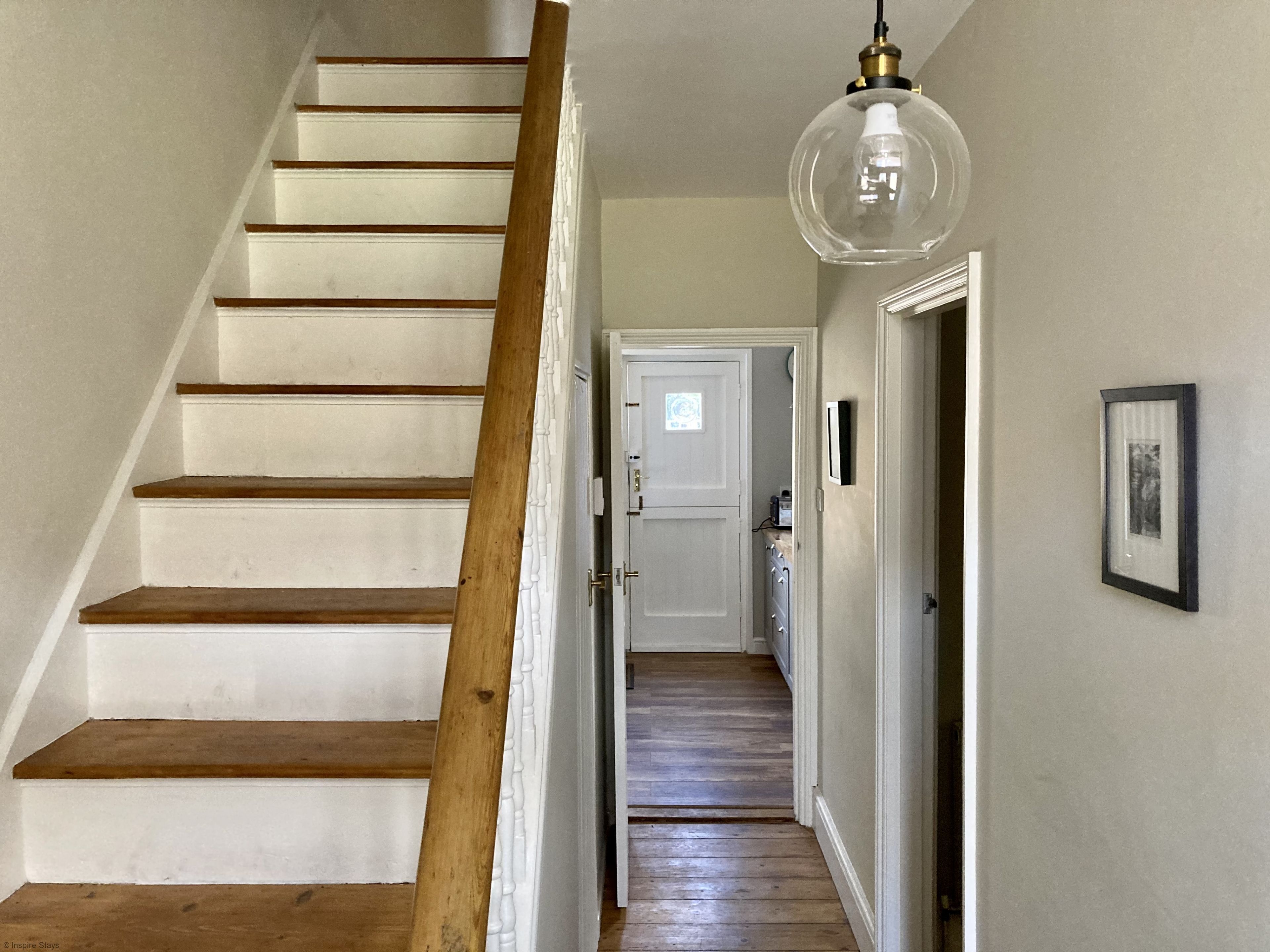 A staircase with wooden steps and a white wall.