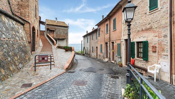A narrow cobblestone street flanked by historic stone buildings with traditional shutters. - Holiday Home in Ficulle with Pool Access (Ficulle)