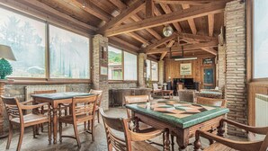 A rustic interior with wooden furniture, stone walls, and large windows offering a view of the forest. - Holiday Home in Ficulle with Pool Access (Ficulle)