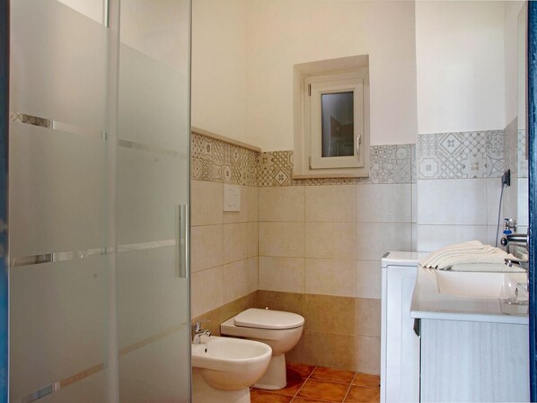 A bathroom with a toilet, bidet, and sink.