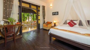 A hotel room with a bed, a desk, and a dining area. - Marirath Boutique Hotel  (Siem Reap)