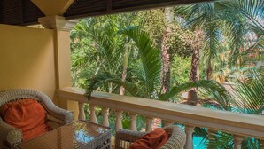 A balcony with wicker furniture and a view of tropical foliage. - Marirath Boutique Hotel  (Siem Reap)