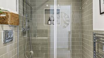 Ein modernes Badezimmer mit einer Duschkabine, einer weißen Toilette und einem Handtuchhalter.