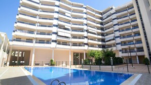 Ein mehrstöckiges Hotel mit einem Pool im Innenhof.