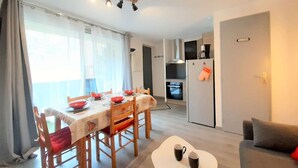 Un espace de vie compact comprenant un coin repas, une kitchenette et un canapé.