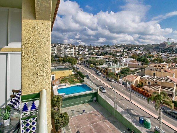 A residential area with a swimming pool, a tennis court, and a road with cars. - Beachfront apartment with pool in Rincón de la Victoria (Rincón de la Victoria)