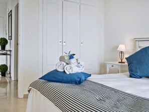 A hotel room with a bed, a nightstand, a lamp, and a wardrobe. - Beachfront apartment with pool in Rincón de la Victoria (Rincón de la Victoria)