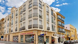 Ein mehrgeschossiges Gebäude mit einem Geschäft im Erdgeschoss, das "ALIMENTACION Y MINIBAZAR" heißt.