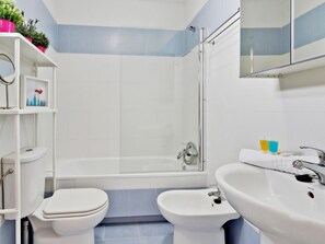A bathroom with a toilet, bidet, bathtub, and sink. - Stunning duplex with terrace in the heart of Malaga (Málaga)