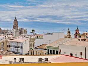 A cityscape with historic buildings, a prominent church tower, and a clear sky. - Stunning duplex with terrace in the heart of Malaga (Málaga)