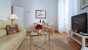 Un soggiorno con un divano, un tavolino, una TV e un'area pranzo con tavolo e sedie.