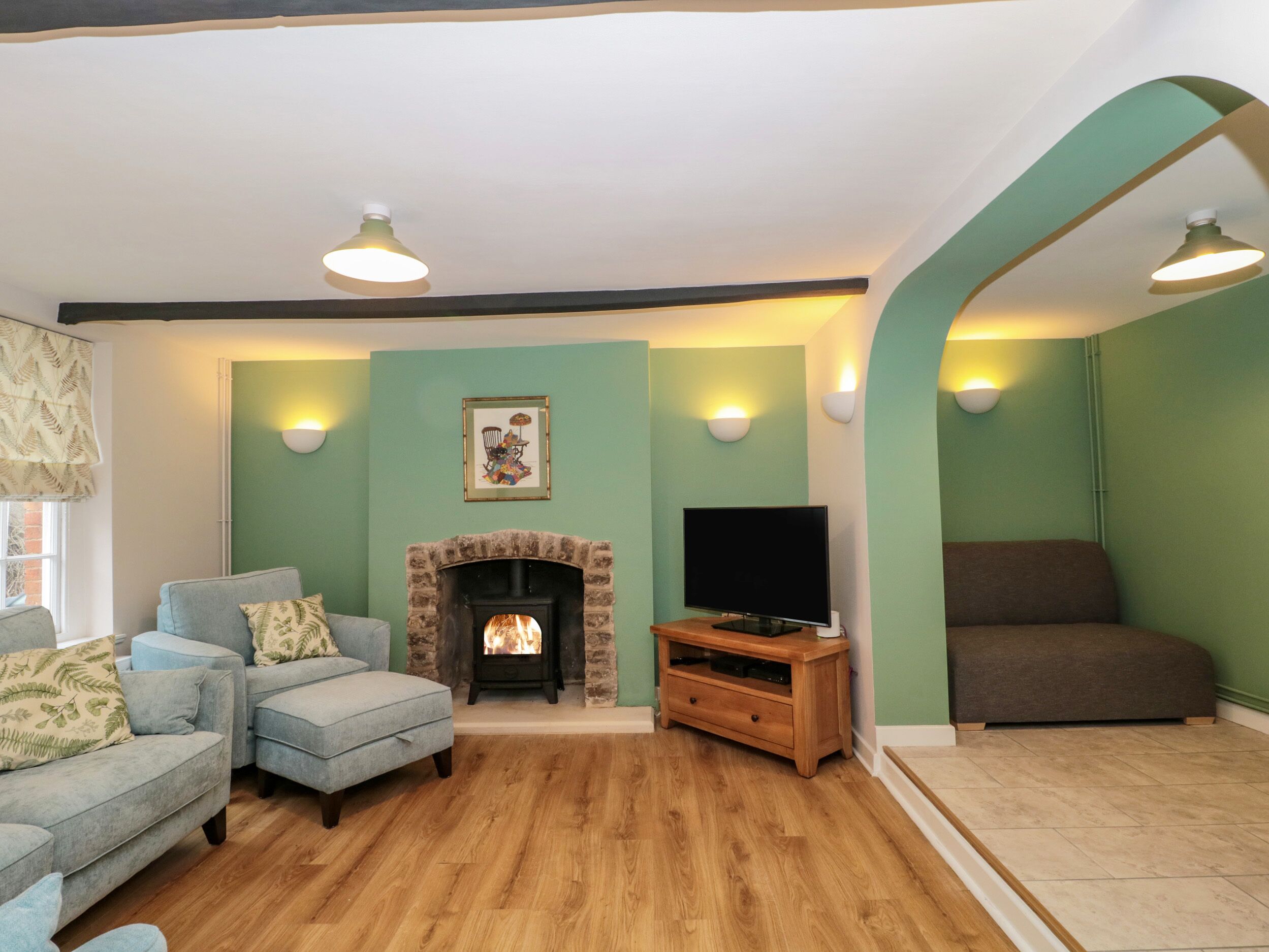 Una sala de estar con chimenea, televisor y dos sofás.