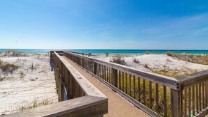 A wooden boardwalk leading to a beach with clear blue water and sandy dunes. - Commodores Retreat - 101 1 Bedroom Condo by RedAwning (Santa Rosa Beach)