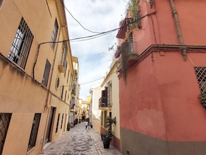 Una calle estrecha flanqueada por edificios con balcones y ventanas.