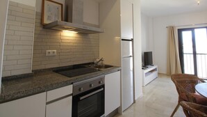 Uma cozinha moderna com forno embutido, geladeira de aço inoxidável e fogão a gás.