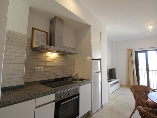 Una cucina moderna con forno integrato, frigorifero in acciaio inossidabile e piano cottura a gas.