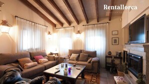 A spacious living room with a fireplace, a television, and a comfortable seating area.