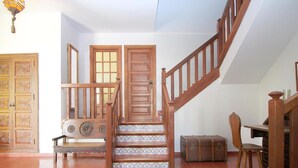 A staircase with wooden railings leading to a landing, a bench, and a suitcase on the floor. - Luxury Villa with Private Pool, Near Beach and Golf (Málaga)