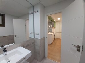 A modern bathroom with a large mirror, two sinks, and a shower area. - Charming 1BR Apartment in 19th-Century Building with Modern Amenities, Málaga (Málaga)
