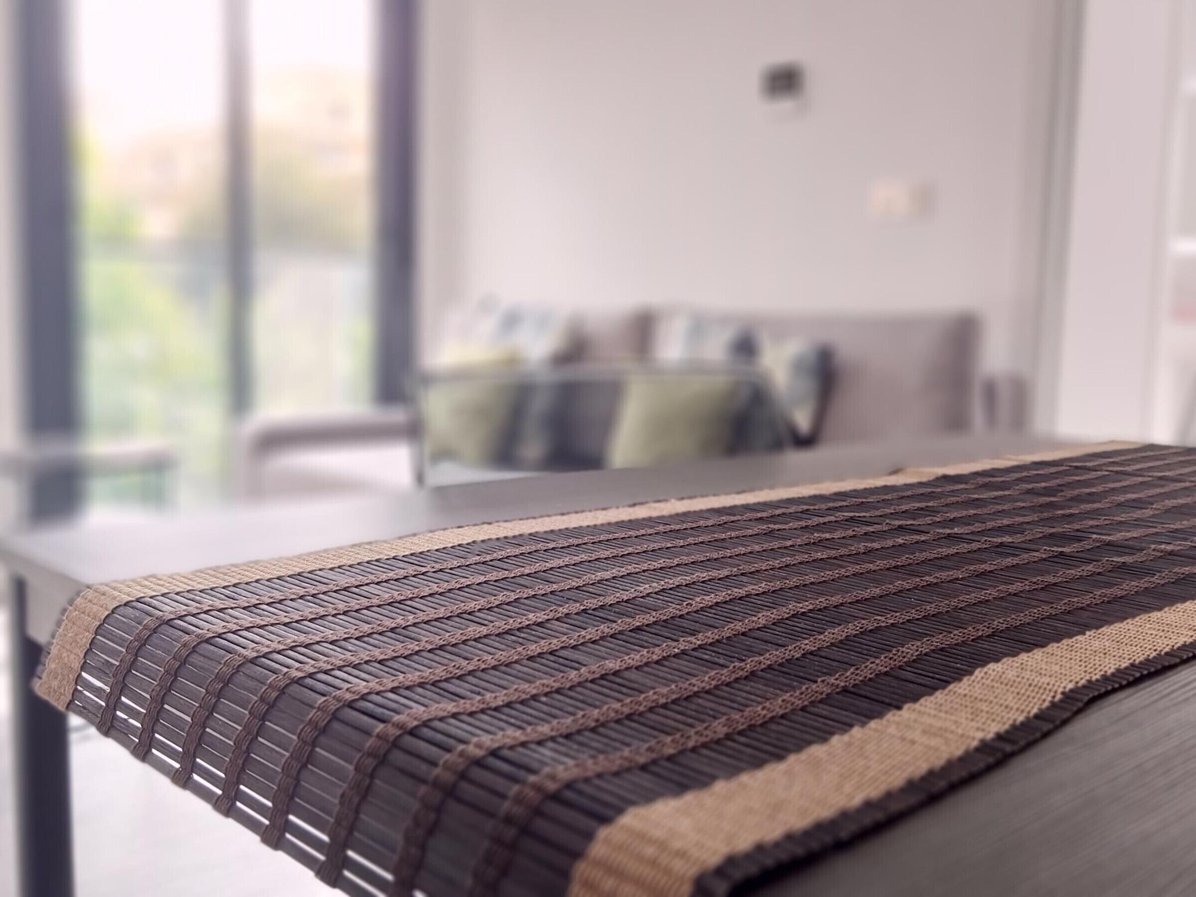 Ein modernes Wohnzimmer mit einer Couch, einem Couchtisch und Blick ins Freie.