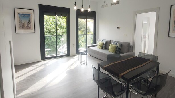 A modern living room with a dining area, large windows, and a balcony. - Bright 1BR Corner Apt, 3 Balconies, Central Málaga - Ideal for Work & Leisure (Málaga)