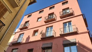 A multi-story building with balconies, windows, and a satellite dish.