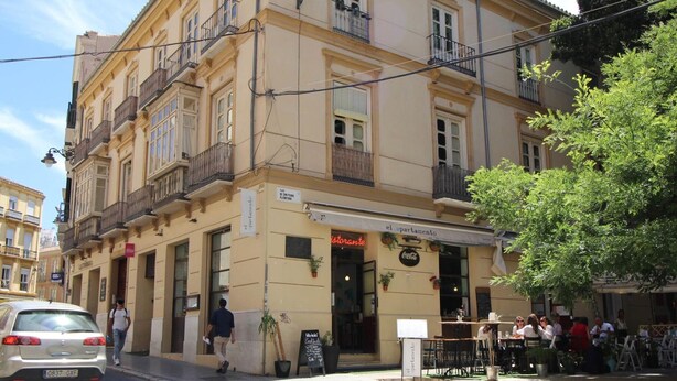 A building with a restaurant named 'el apartamento' on the ground floor. There is a sign for 'el parador' above the entrance.