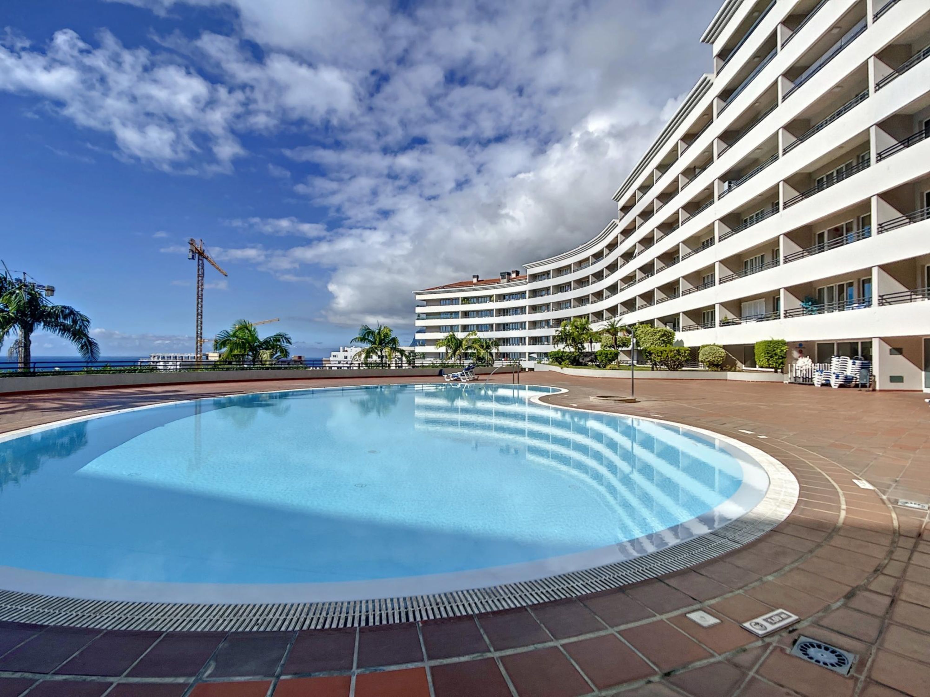 Un hôtel doté d’une grande piscine, de nombreux balcons et offrant une vue sur l’océan.