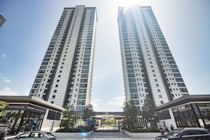 Stylish high-rise building with a central entrance and commercial establishments below.