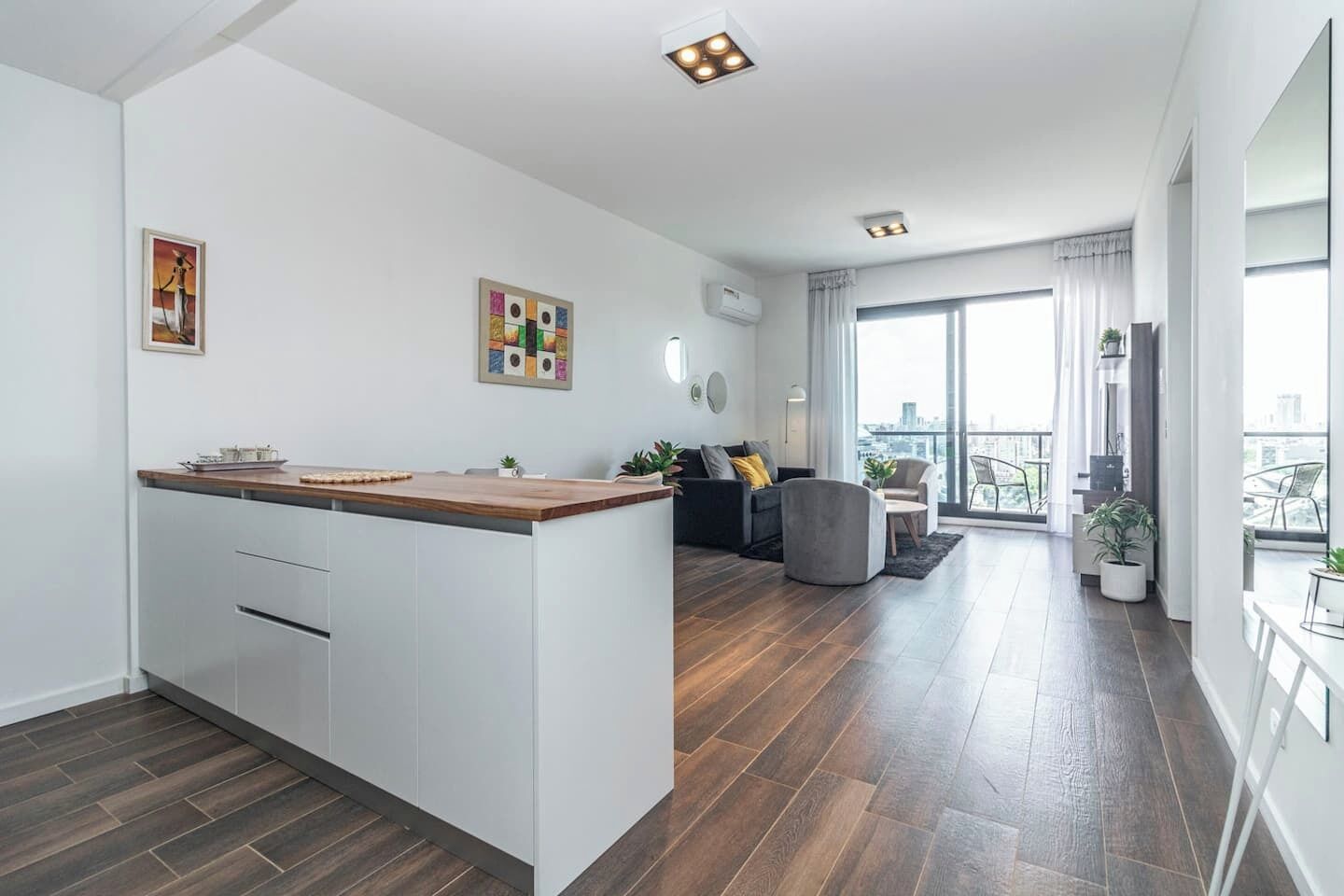 Un apartamento moderno con cocina, sala de estar y balcón con vistas a la ciudad.