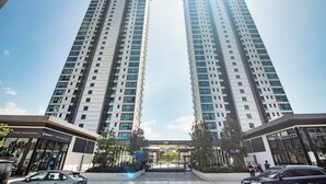 Two tall residential buildings with a clear sky.