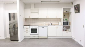 A kitchen with white cabinets, a stainless steel refrigerator, a microwave, an oven, and a dishwasher.