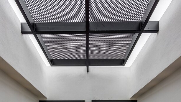 Ein modernes Interieur mit einer corridorartigen Halle, einem Oberlicht und zwei beleuchteten Wandzahlen.