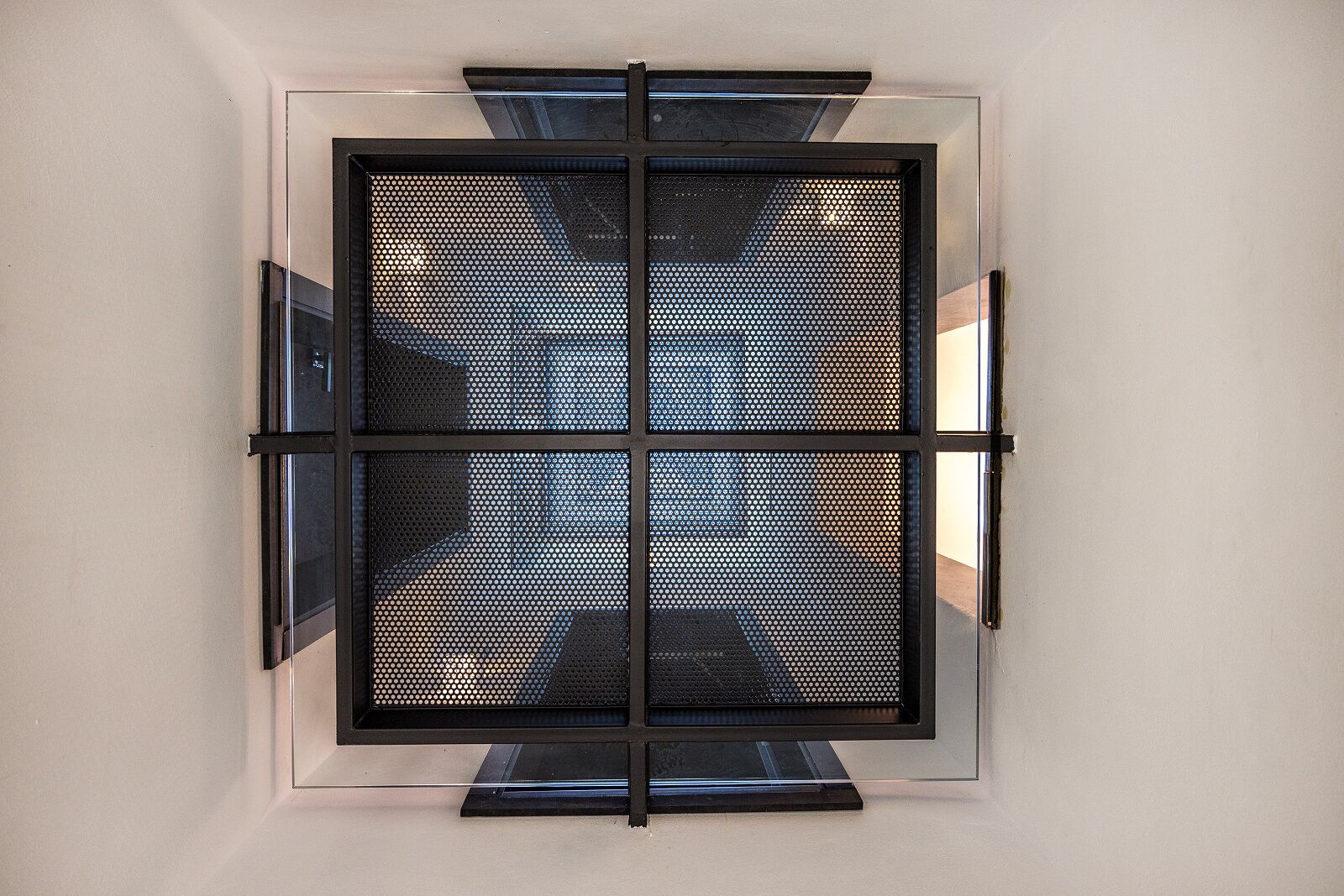 Un diseño de ventana moderno y geométrico con un patrón de rejilla metálica.