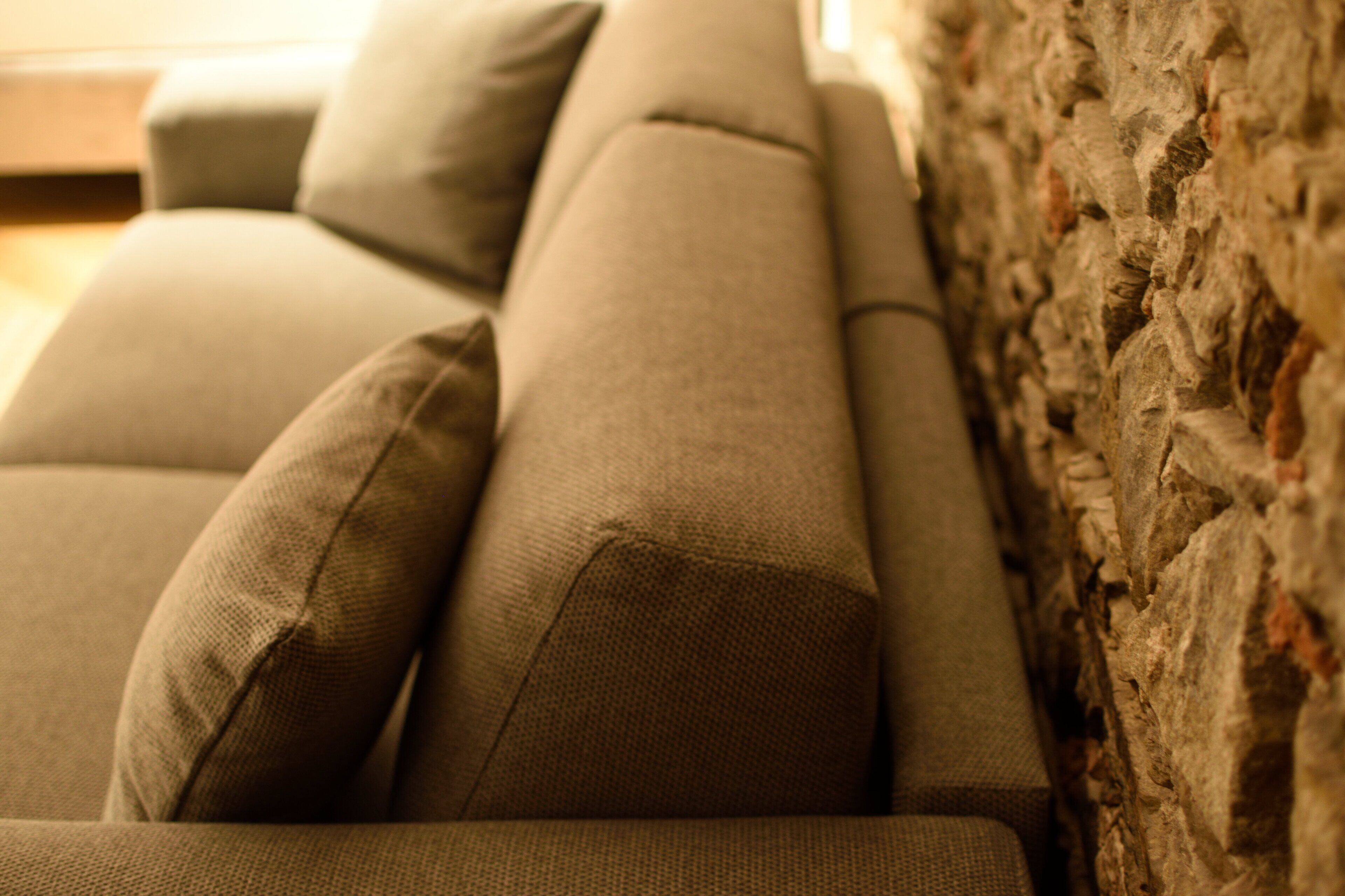 Primer plano de un sofá con una pared texturizada al fondo.