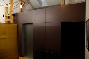 Una habitación con un armario de madera, un radiador y una puerta.
