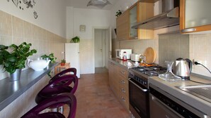 Una cocina moderna con estufa de acero inoxidable, armarios de madera y salpicadero de azulejos.