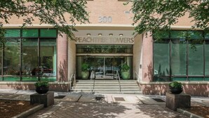 L’entrée de Peachtree Towers se distingue par sa façade en briques, ses grandes fenêtres et un escalier menant à l’entrée.