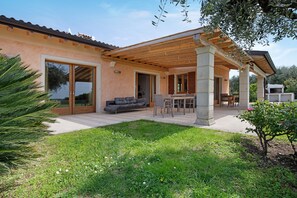 A house with a covered patio, a dining area, and a large sliding glass door.