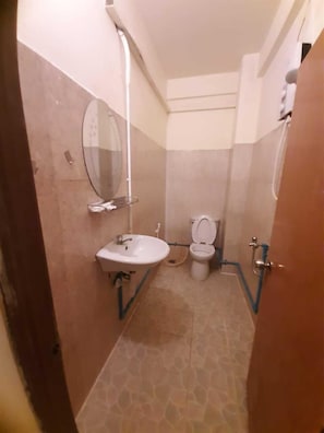 Un baño pequeño con lavamanos, inodoro y espejo.