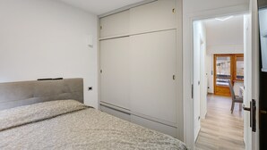 A bedroom with a bed, a wardrobe, and a door leading to another room. - Apartment 'Gianpaolo' with Mountain View, Shared Garden and Wi-Fi (Piode)