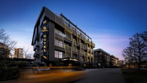 A modern hotel with a prominent sign, multiple floors, and a distinctive facade. - The Alpfine Hotel (Ankara)
