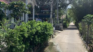 A narrow street with a sign for 'Lambuli' and a contact number. - LAM PHU Bungalow (Phu Quoc)