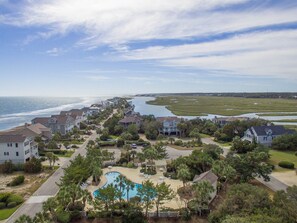 A coastal residential area with houses, a swimming pool, and a view of the ocean.